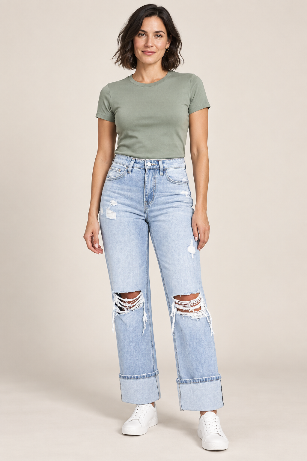 Woman wearing Beau Blue light-wash distressed straight-leg jeans in a studio.
