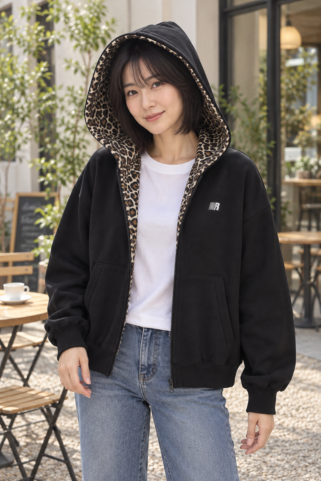 Women's black cardigan jacket worn open, showing leopard detail inside the hood and front opening.