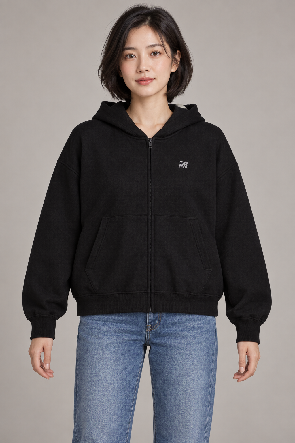 Women's black zip-front hooded cardigan jacket with chest emblem, studio front view.