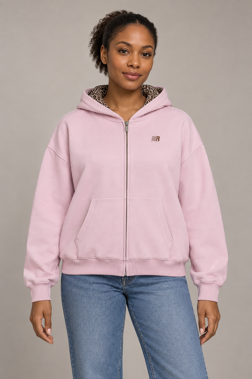 Women's pink zip-front hooded cardigan jacket with chest emblem, studio front view.