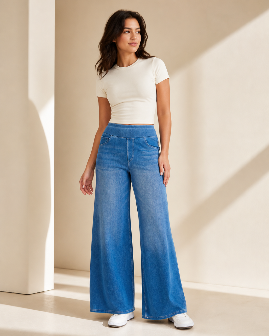 Model wearing high-waist wide-leg jeans in a medium blue wash