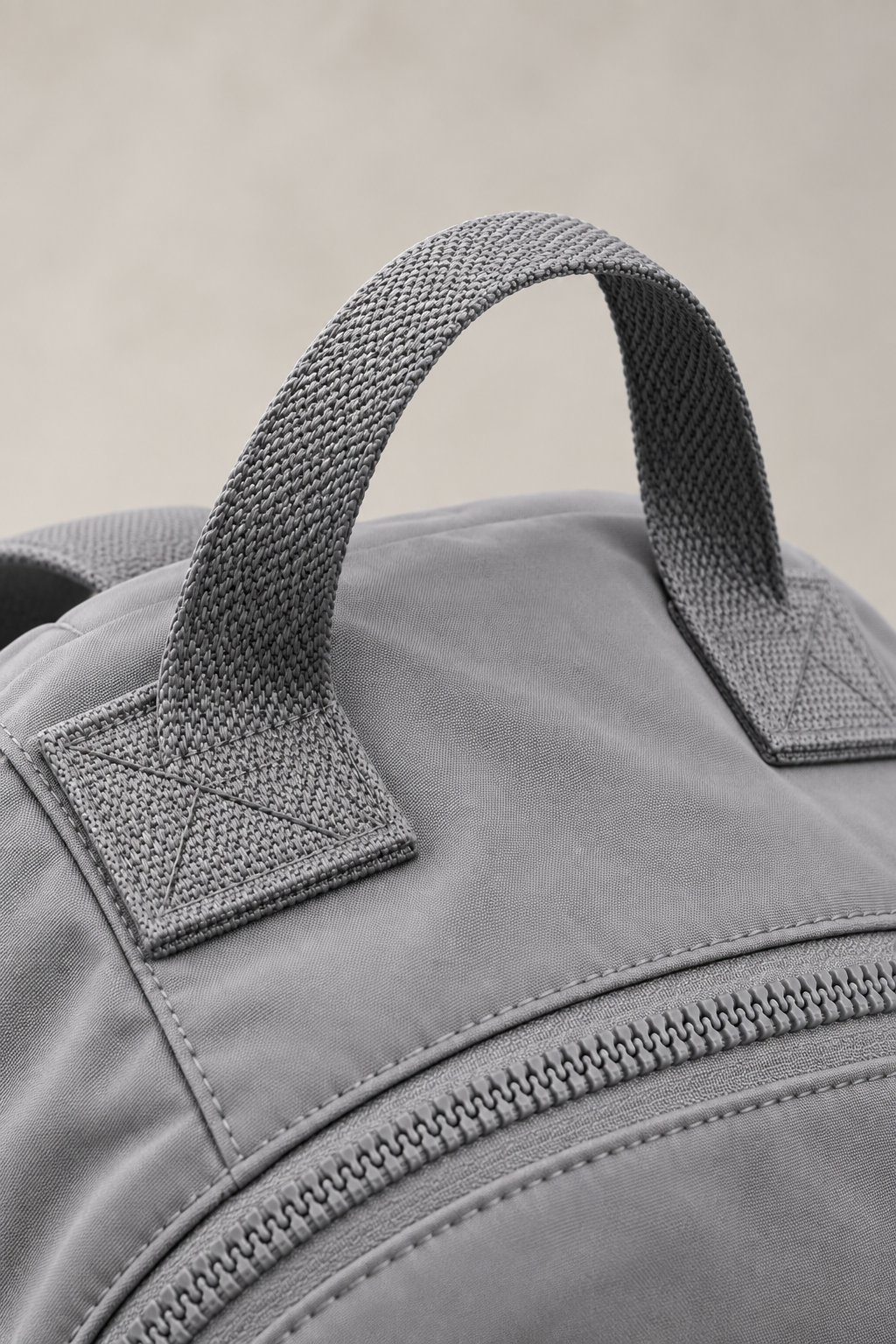 Women’s grey compact nylon travel backpack exterior handle detail (interior substitute)