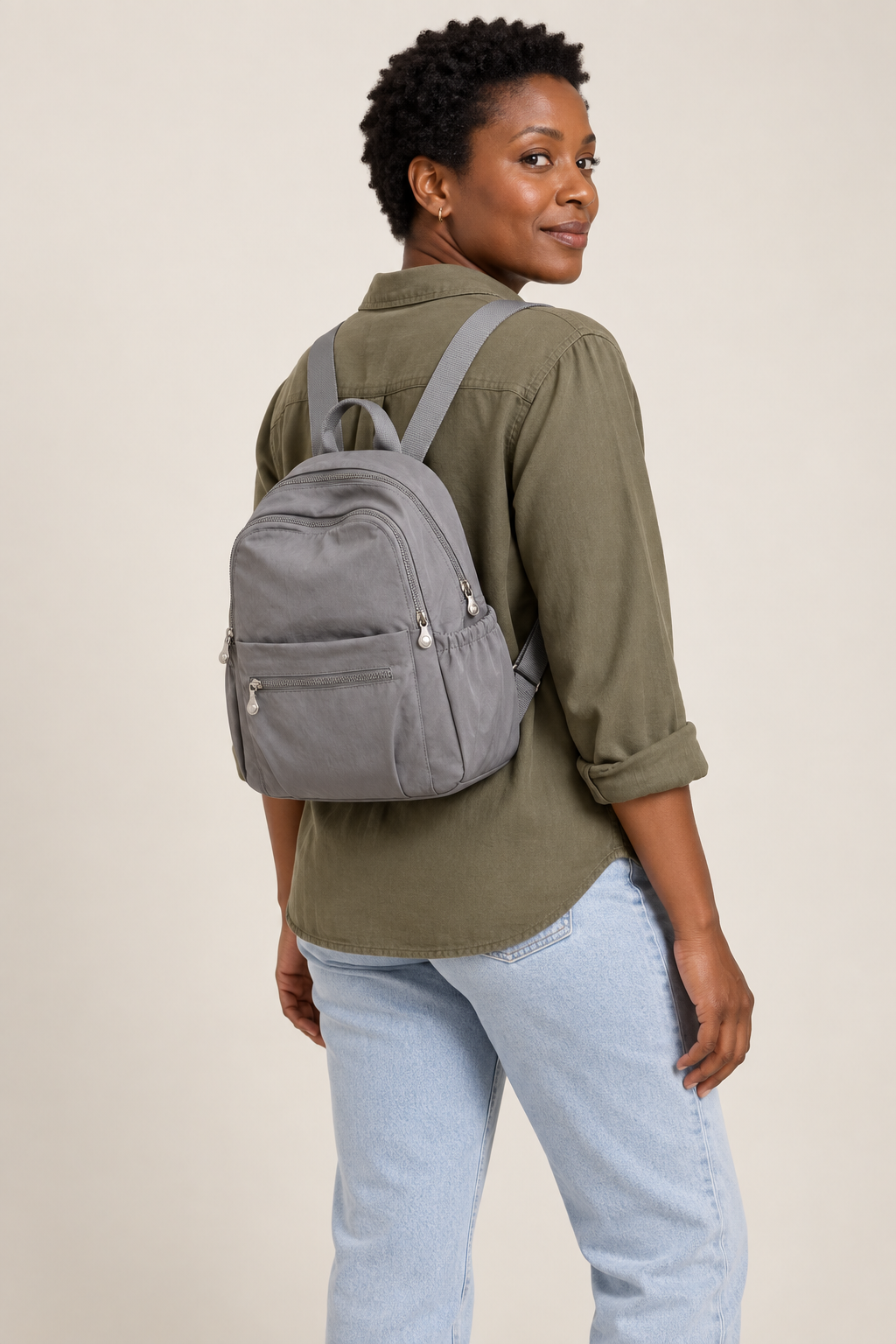 Women’s grey compact nylon travel backpack on-body scale