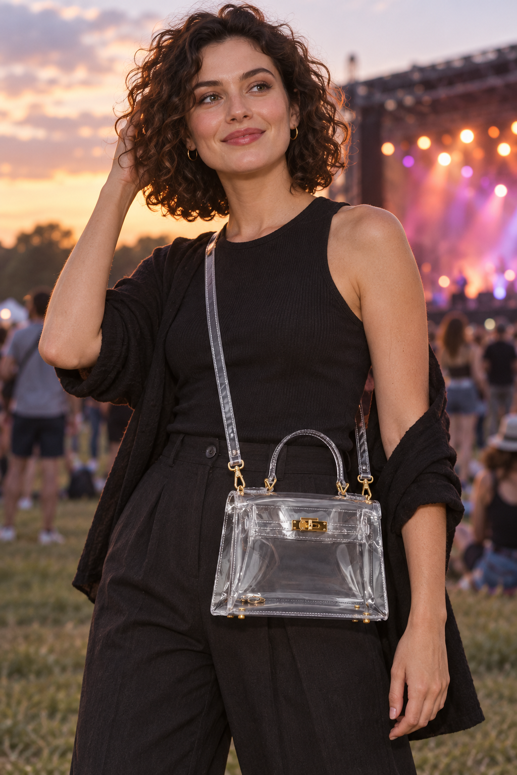 Woman carrying AuraX transparent PVC handbag with gold-tone hardware at an outdoor music event