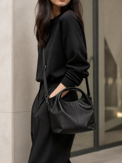 Model wearing black leather dumpling crossbody shoulder bag