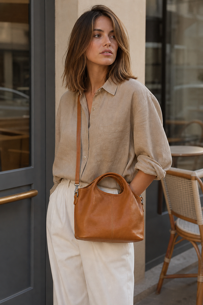 Model wearing caramel leather dumpling crossbody shoulder bag
