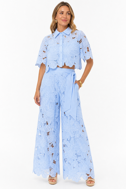 Model wearing light blue floral lace two piece co-ord on white studio background