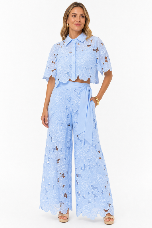 Model wearing light blue floral lace two piece co-ord on white studio background