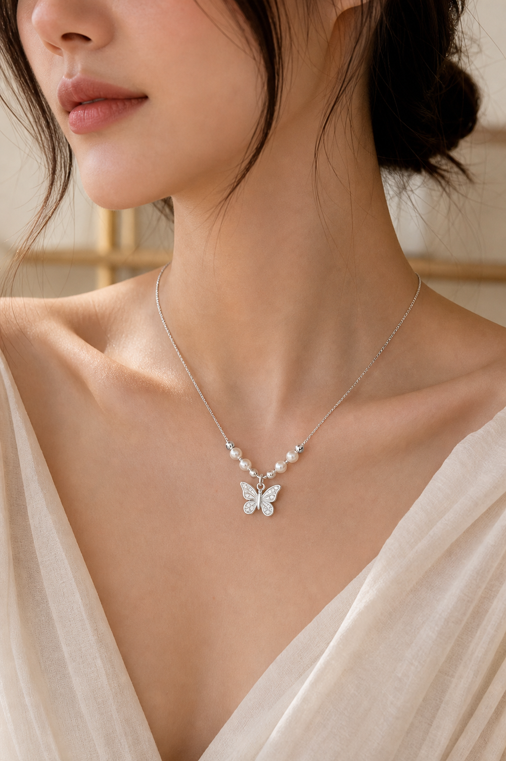 Model wearing silver butterfly pearl necklace